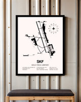 Kelly Field Airport framed poster displayed in an airplane hangar