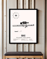 Williamson / Sodus Airport framed poster displayed in an airplane hangar