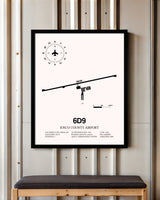 Iosco County Airport framed poster displayed in an airplane hangar