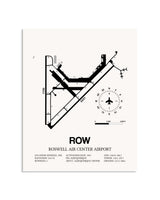 Gray Roswell Air Center Airport framed poster displayed in an airplane hangar