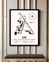Conroe / North Houston Regional Airport framed poster displayed in an airplane hangar