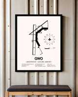 Greenwood-Leflore Airport framed poster displayed in an airplane hangar