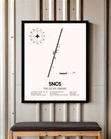 The Duchy Airport framed poster displayed in an airplane hangar