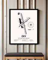 Outlaw Field Airport framed poster displayed in an airplane hangar