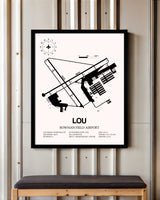 Bowman Field Airport framed poster displayed in an airplane hangar