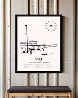 Pueblo Memorial Airport framed poster displayed in an airplane hangar